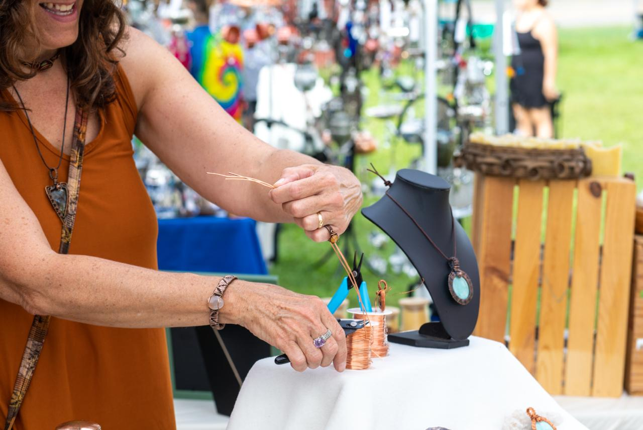Tammy wire-wrapping jewelry at her craft fair booth
